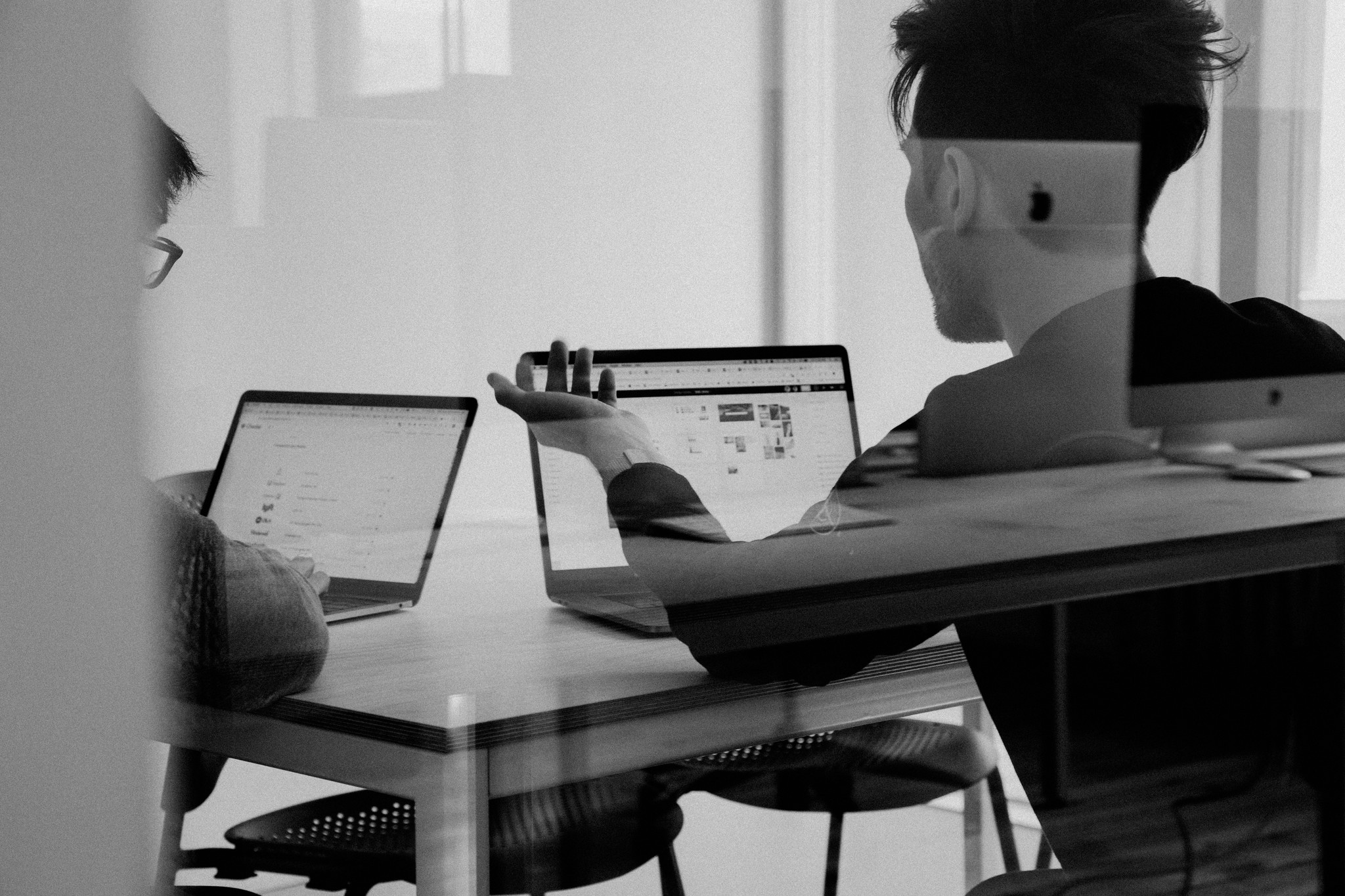 Zwei Personen vergleichen an Laptops Pseudonymisierung und Anonymisierung.
